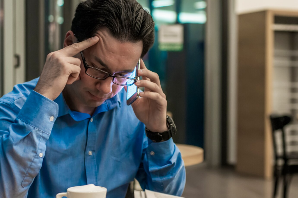 Homem com expressão de dificuldade visual, possível sintoma de ambliopia.