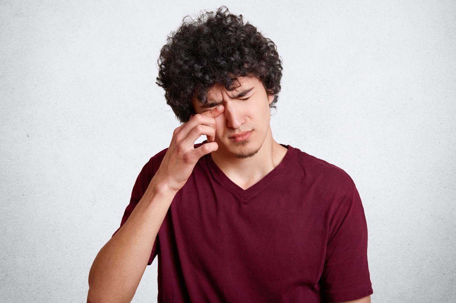 Homem cansado esfregando os olhos.